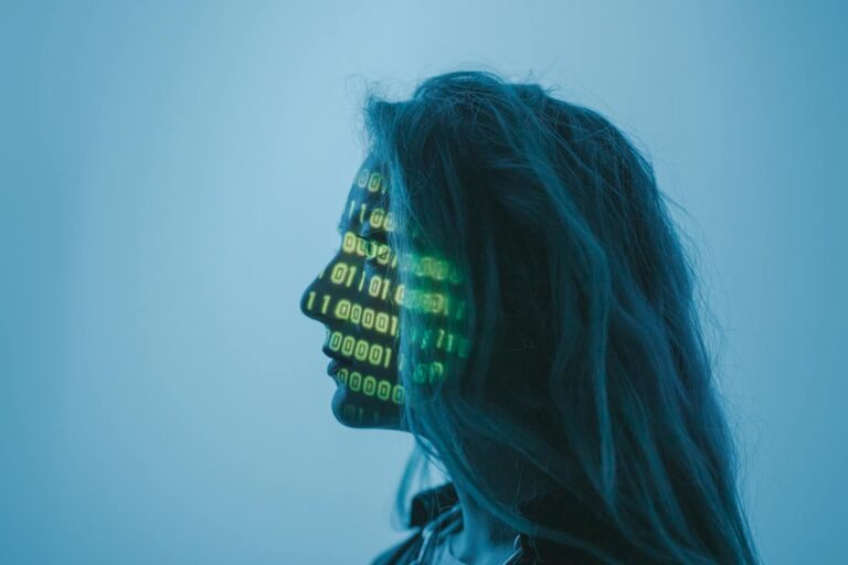 Silhouette of a woman with binary code projected on her face in a digital concept setting.